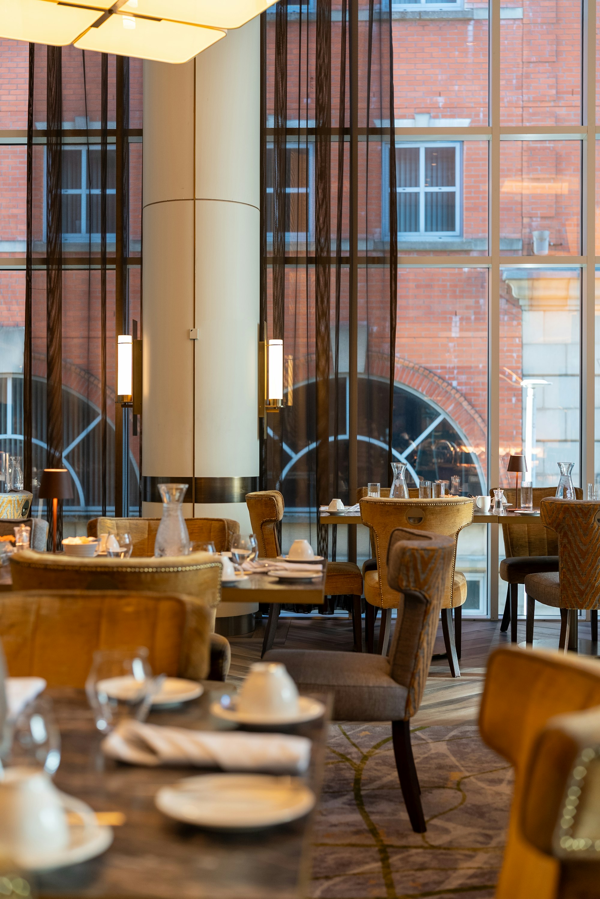 Photo: Franco Debartolo / Unsplash Elegant restaurant dining room with upholstered seating and tall windows